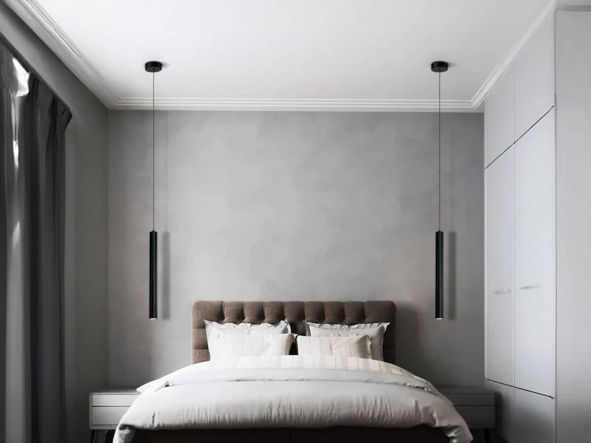 Suspension LED tube noir au design nordique moderne Chambre avec un grand lit et une tête de lit capitonnée marron, et une suspension LED tube noire de chaque côté du lit en guise de lampe de chevet.