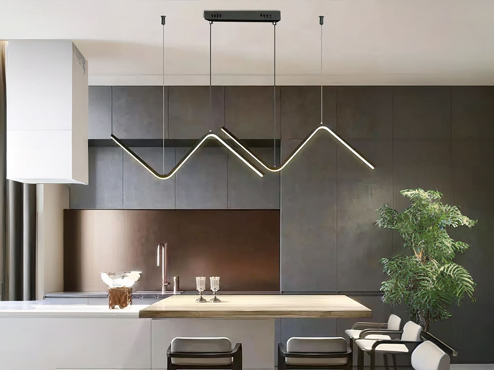 Suspension LED noire, en forme de vague, installée au-dessus d'un mange-debout dans une cuisine très moderne.