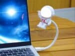 Veilleuse LED flexible en forme d'astronaute allumée et branchée à un ordinateur