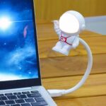 Veilleuse LED flexible en forme d'astronaute Veilleuse LED flexible en forme d'astronaute allumée et branchée à un ordinateur