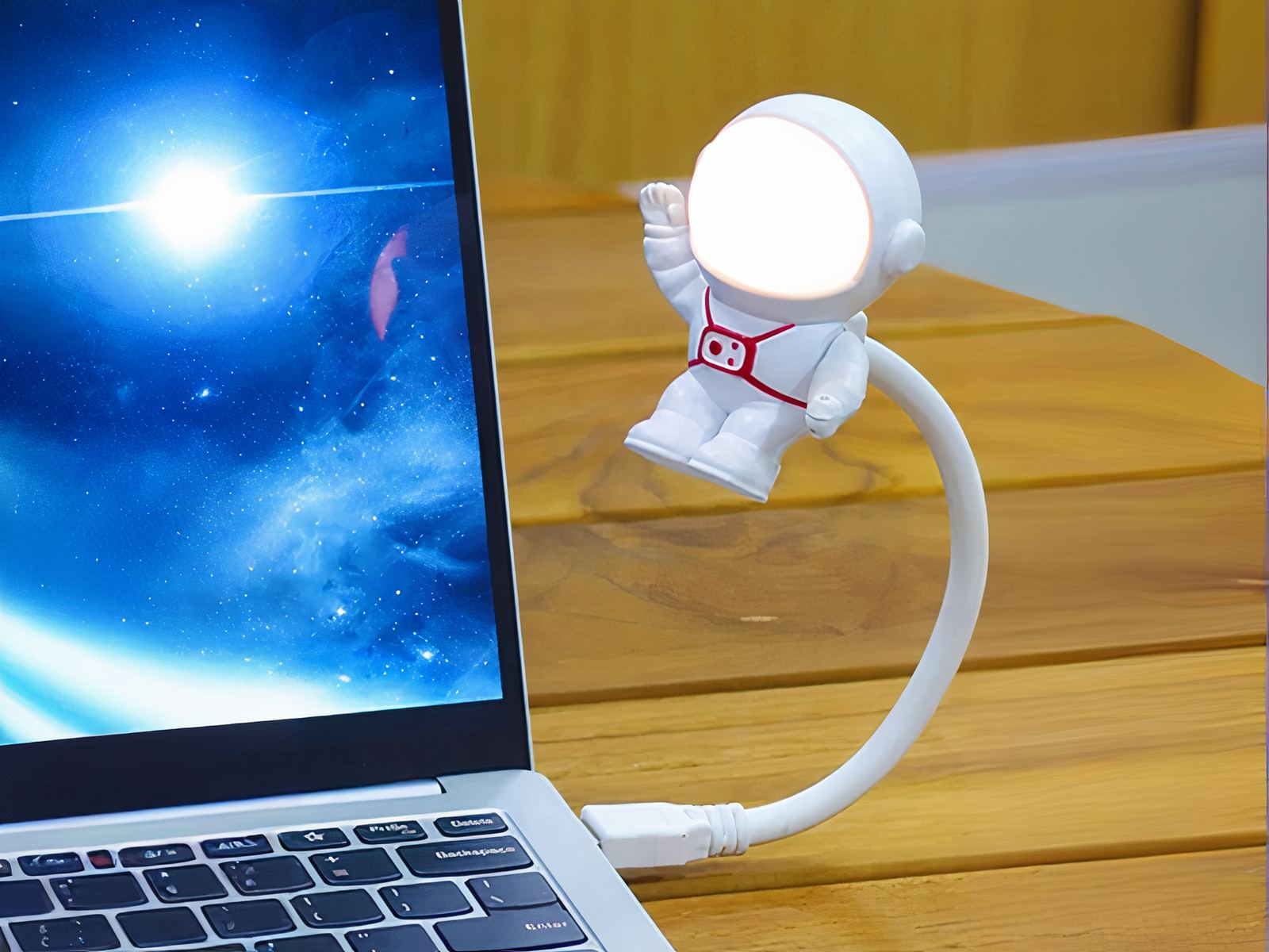 Veilleuse LED flexible en forme d'astronaute allumée et branchée à un ordinateur