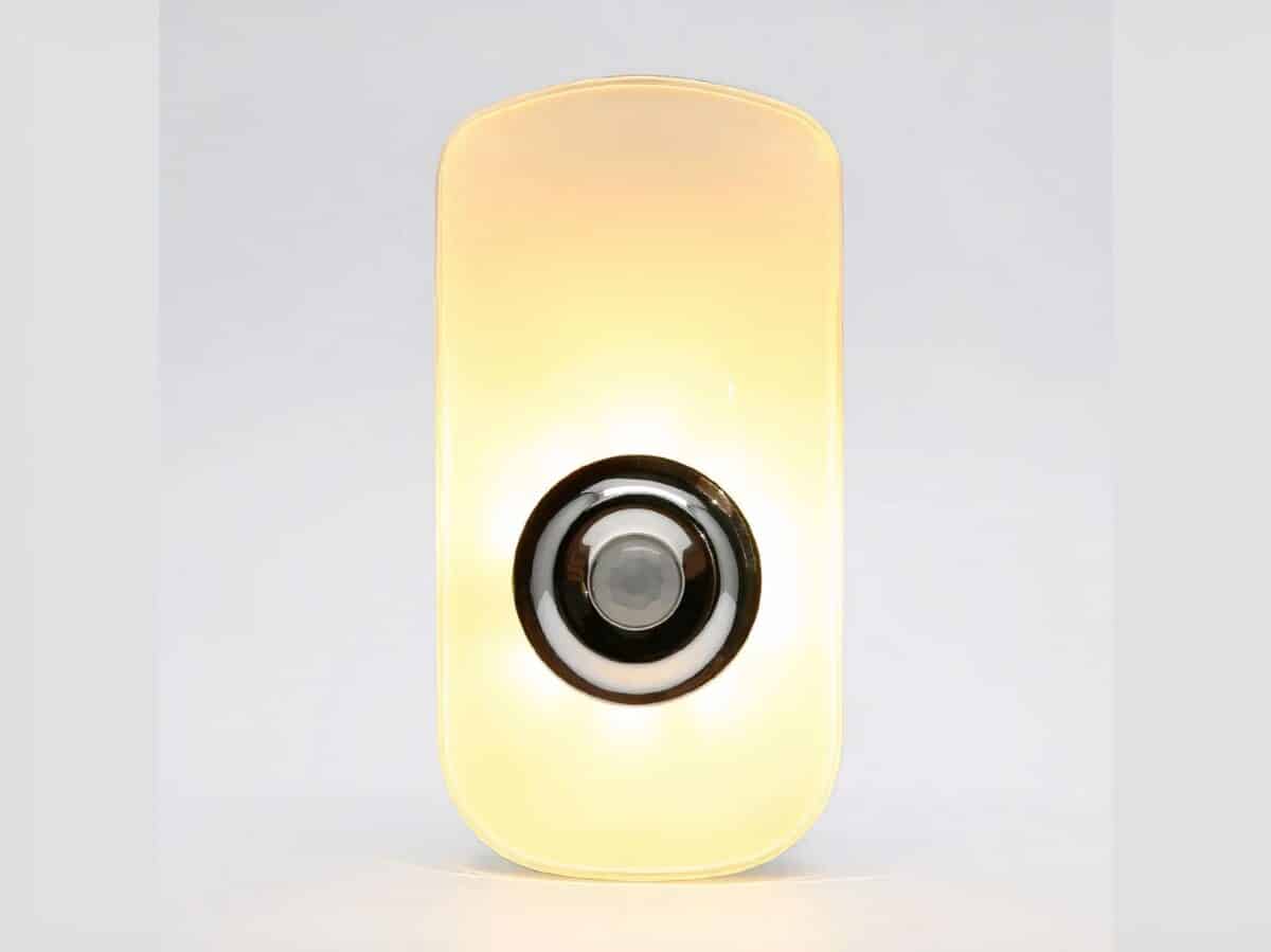Lampe LED rechargeable design avec détecteur sur fond gris.