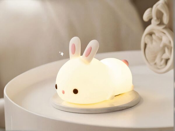 Lampe LED rechargeable style veilleuse lapin sur une table avec un réveil à côté