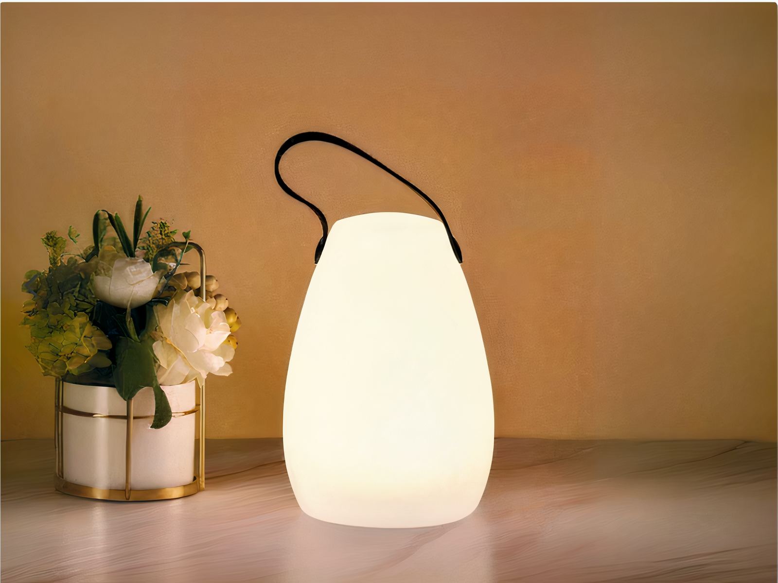 Lampe LED rechargeable télécommandée style lanterne posée sur une table avec un bouquet de fleurs