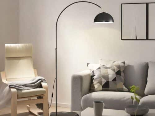 Lampadaire LED noir design et moderne, au dessus d'un canapé.