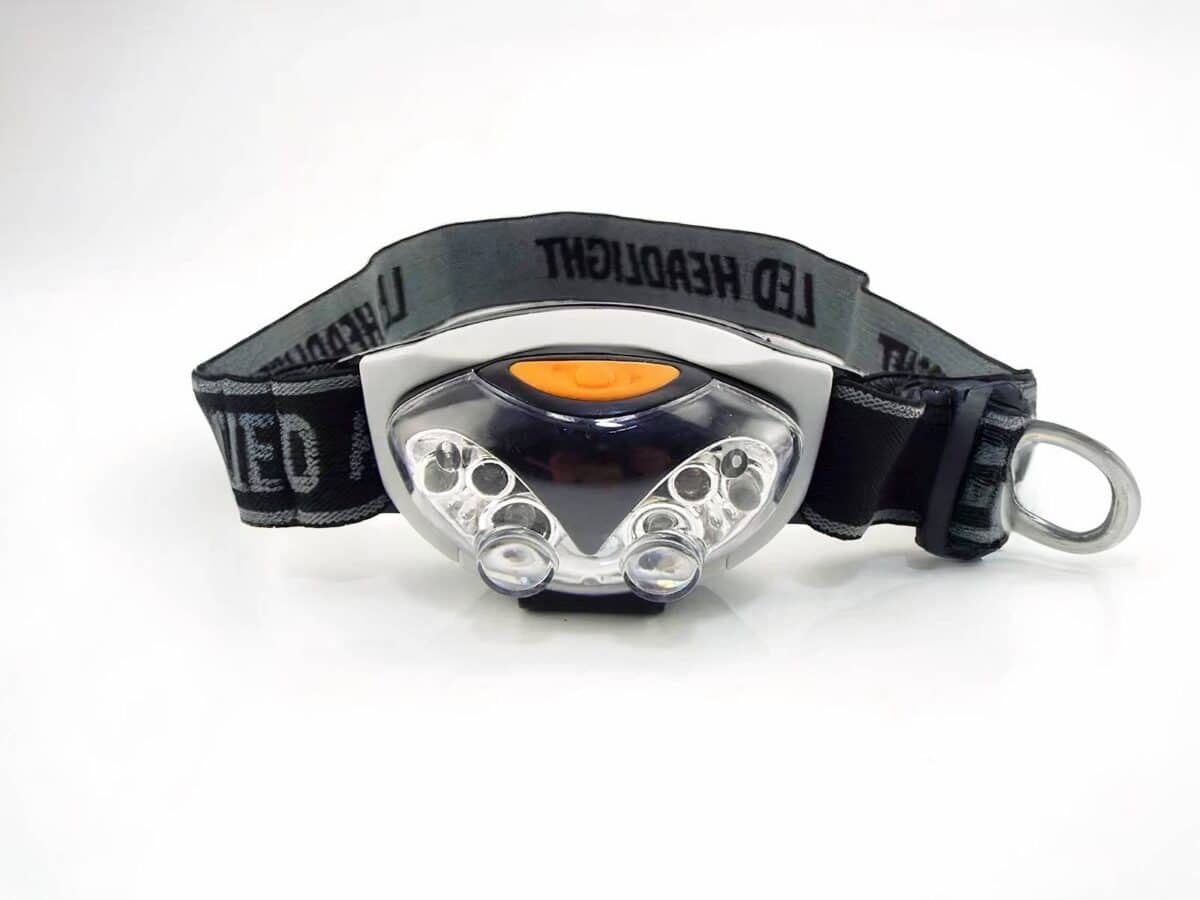 Lampe frontale LED 3 modes Lampe frontale LED noire et grise, avec un bouton orange et un bandeau réglable noir et gris.