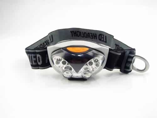 Lampe frontale LED noire et grise, avec un bouton orange et un bandeau réglable noir et gris.