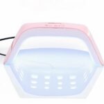 Lampe LED ongle rose compacte et puissante Lampe LED ongle rose et blanche, compacte et puissante, allumée sur fond blanc.
