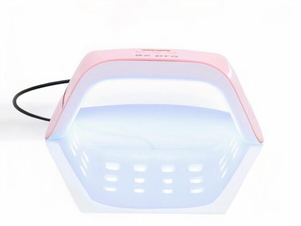 Lampe LED ongle rose et blanche, compacte et puissante, allumée sur fond blanc.