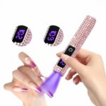 Lampe LED ongle UV mini strass roses avec écran Lampe LED UV mini à strass rose, avec écran tactile, allumée et dans les mains d'une mannequin qui sèche son vernis. On ne voit que ses mains.
