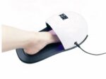 Lampe LED ongle UV ergonomie pied, noire et blanche, avec le pied d'une personne. Sur fond blanc.
