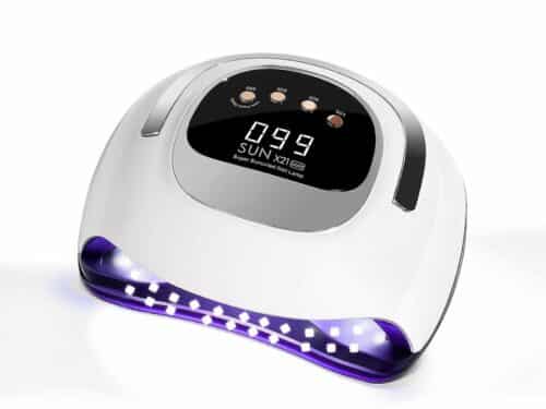 Lampe LED ongle UV pour vernis gel, allumée, blanche avec un écran noir et des boutons beiges, sur un fond blanc.