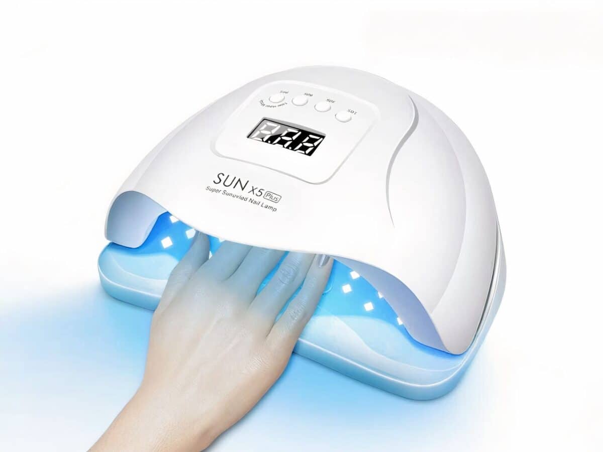 Lampe LED ongle UV, blanche, allumée, une femme y met la main.