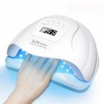 Lampe LED ongle UV tous types de vernis Lampe LED ongle UV, blanche, allumée, une femme y met la main.