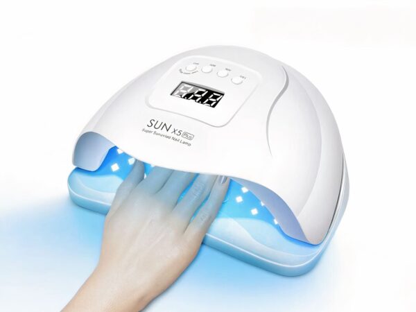 Lampe LED ongle UV, blanche, allumée, une femme y met la main.