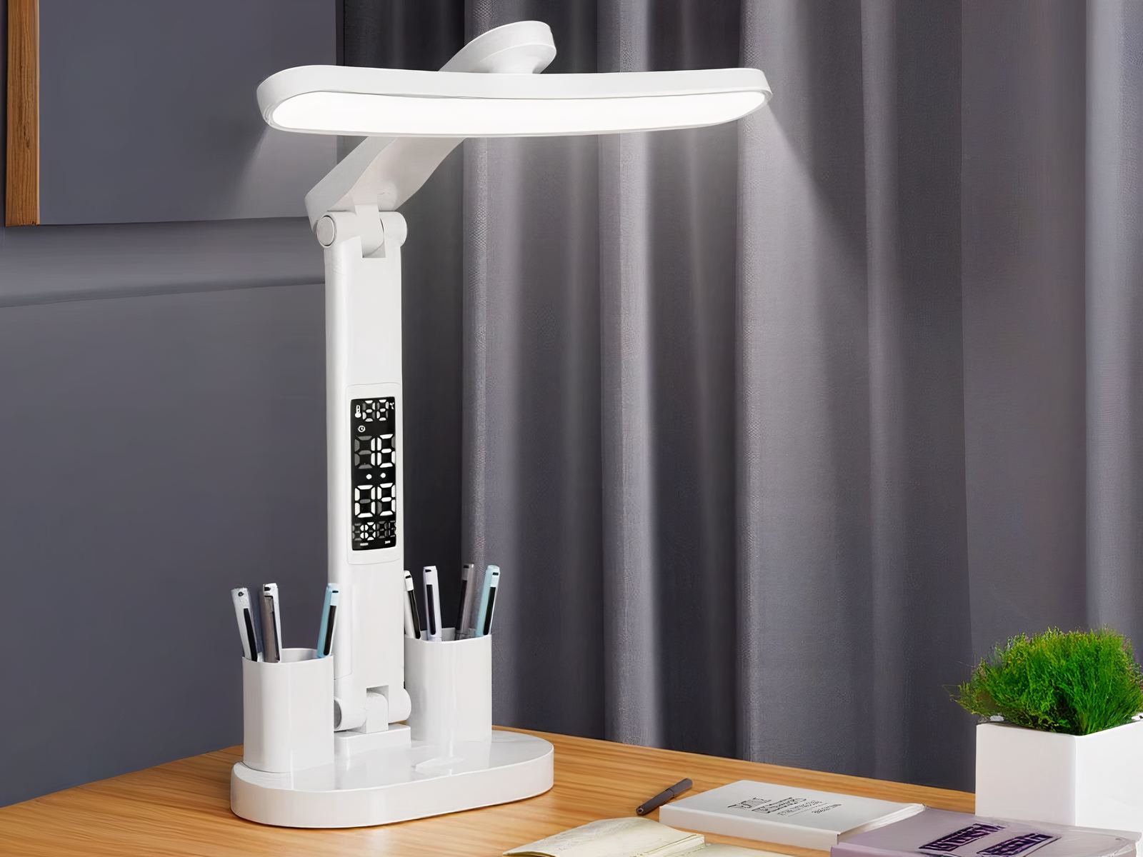 Lampe LED sans fil fonctionnelle de bureau posée sur un bureau avec des livres et des stylos