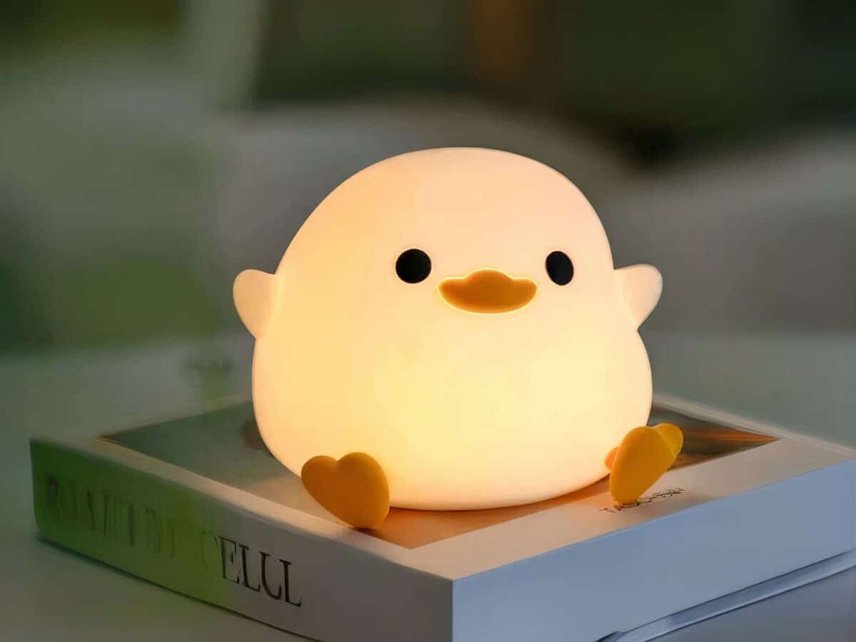 Lampe LED sans fil tactile en forme de canard posée sur un livre