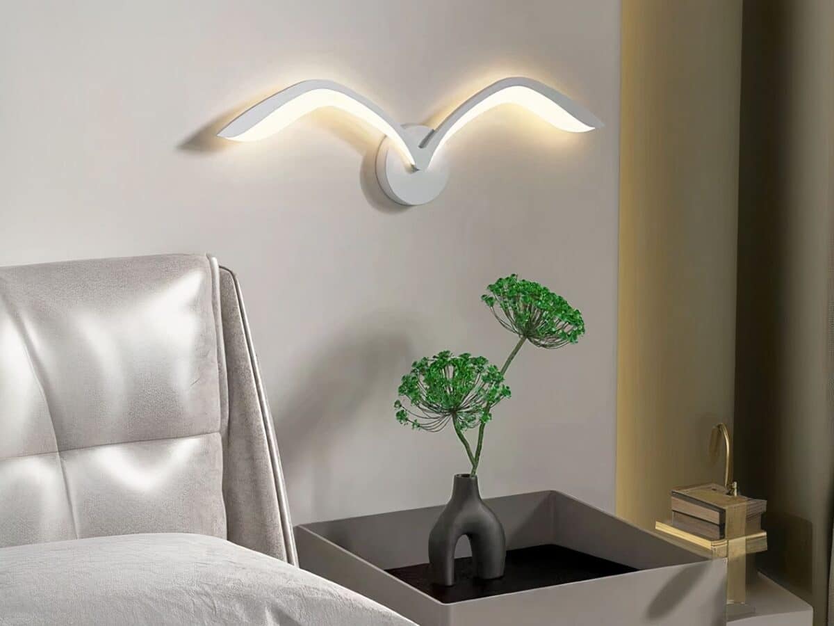 Luminaire LED mural créatif et original en forme d'oiseau Luminaire LED mural créatif et original en forme d'oiseau allumé dans une chambre à côté d'un lit