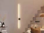 Luminaire LED mural noir élégant et épuré allumé sur un mur