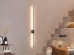 Luminaire LED mural noir élégant et épuré allumé sur un mur