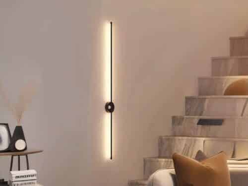 Luminaire LED mural noir élégant et épuré allumé sur un mur