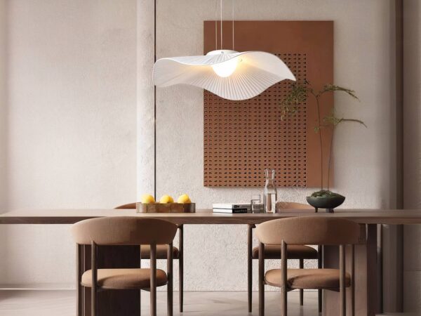 Lustre LED fleur blanche, allumé et installé au-dessus d'une table en bois, avec 4 chaises autour et un tableau sur le mur du fond.