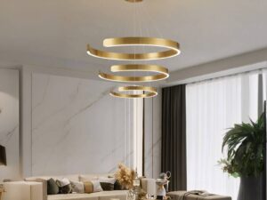 Lustre LED trio circulaire suspendue doré, installé dans un salon.