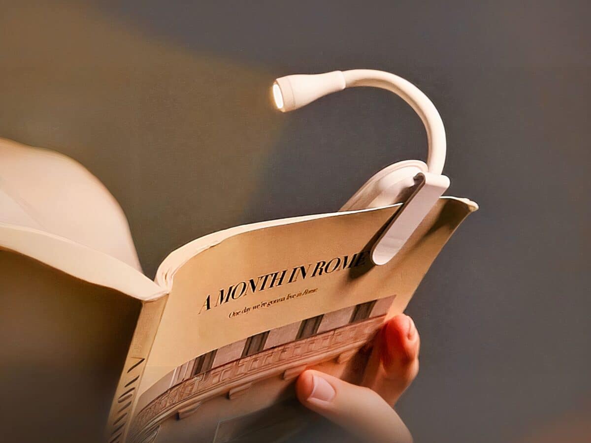Mini lampe LED de lecture avec pince Mini lampe LED de lecture avec pince, de couleur blanche, sur un livre.