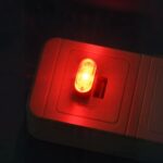 Mini lampe LED style veilleuse USB lumière rouge, sur un fond noir.