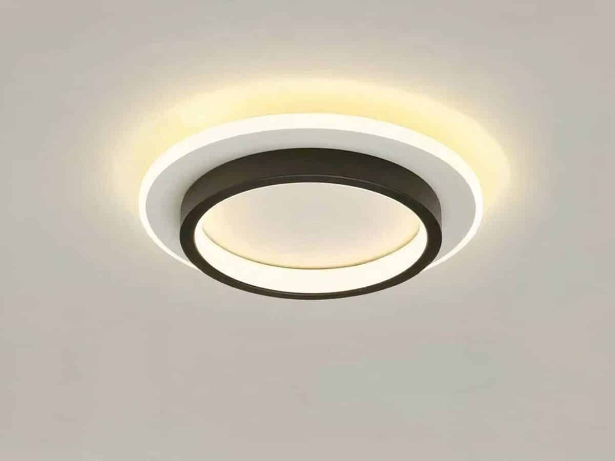 Plafonnier LED métal circulaire noir et blanc Plafonnier LED circulaire noir et blanc allumé et installé sur un plafond gris.