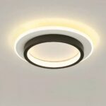 Plafonnier LED circulaire noir et blanc allumé et installé sur un plafond gris.