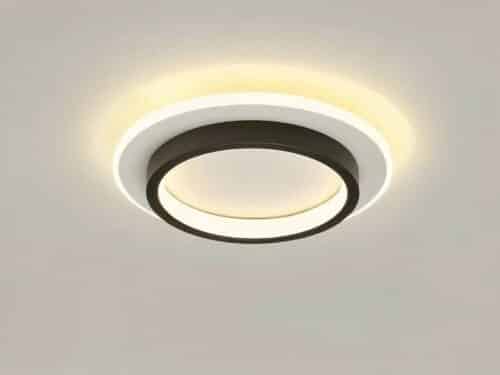 Plafonnier LED circulaire noir et blanc allumé et installé sur un plafond gris.
