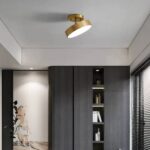 Plafonnier LED nordique métal rond doré Plafonnier LED nordique rond doré, installé sur un plafond gris, dans une pièce de vie. Il est orienté vers la droite et allumé.