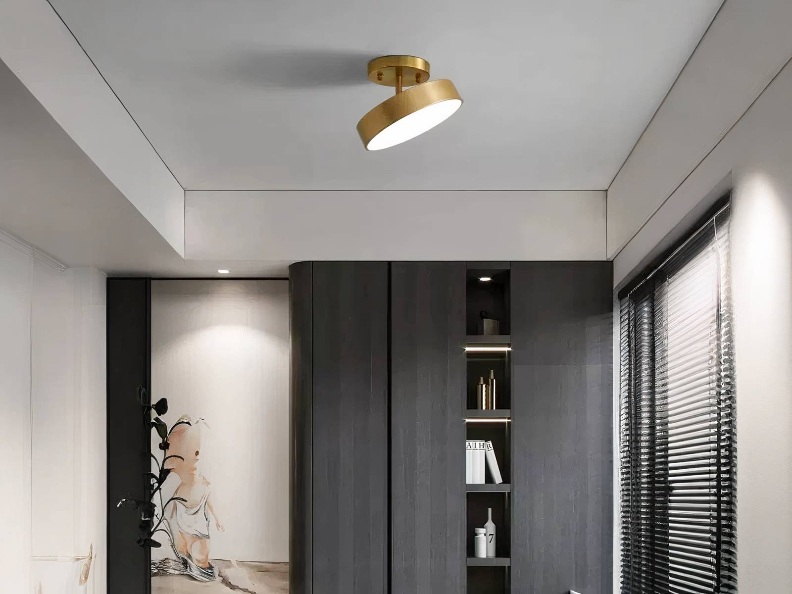 Plafonnier LED nordique rond doré, installé sur un plafond gris, dans une pièce de vie. Il est orienté vers la droite et allumé.