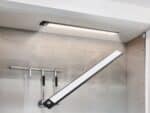 Réglette LED de cuisine noire sans fil, magnétique à détecteur de mouvement, installées sous un meuble haut de cuisine.
