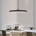 Suspension LED design en forme de soucoupe noire Suspension LED design en forme de soucoupe noire, au dessus d'une table de salle à manger.