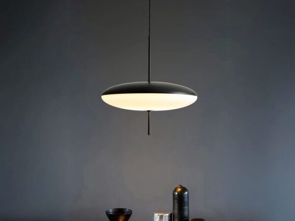 Suspension LED design minimaliste noire et blanche, dans une pièce sombre.