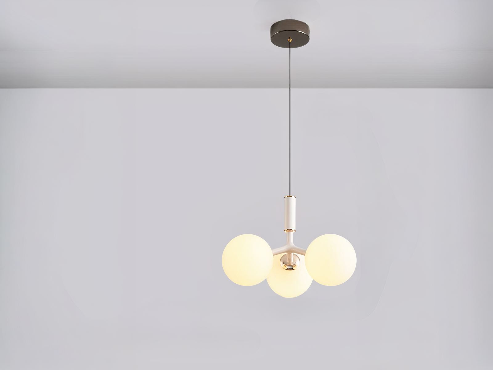 Suspension LED design moderne en métal blanc en forme de grappe, sur un fond gris.