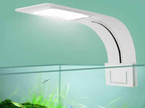 Lampe LED ultra fine pour aquarium de couleur blanche fixée sur le rebord de l'aquarium. Le fond est vert et la lampe est allumée.