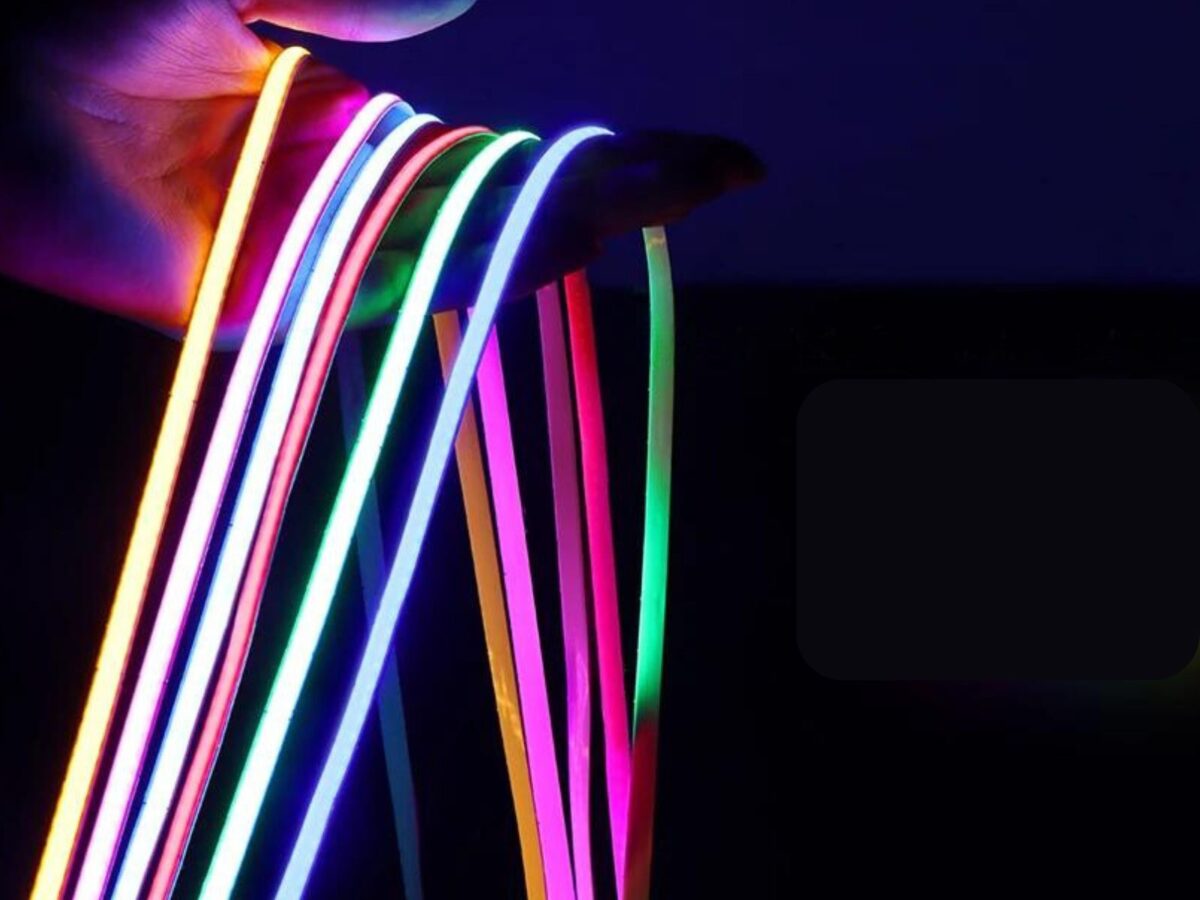 Bande LED COB ultra fine, flexible et colorée, montrant plusieurs rubans lumineux dans une main prête à l’installation, pour un éclairage original et personnalisé.