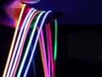 Bande LED COB ultra fine, flexible et colorée, montrant plusieurs rubans lumineux dans une main prête à l’installation, pour un éclairage original et personnalisé.