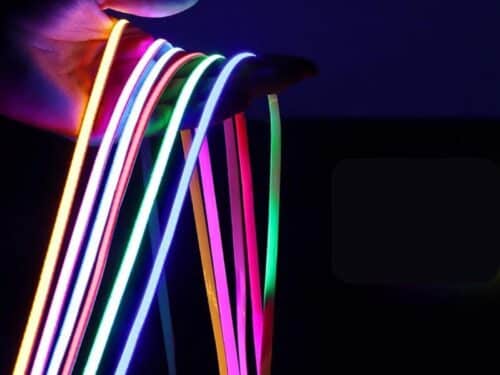 Bande LED COB ultra fine, flexible et colorée, montrant plusieurs rubans lumineux dans une main prête à l’installation, pour un éclairage original et personnalisé.