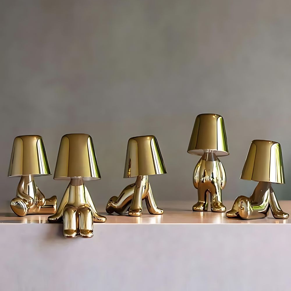 Veilleuses LED tactiles dorées, en forme de personnage dans des postures assises ou debouts avec un abat-jour brillant, apportant une lumière douce et une touche moderne à votre espace