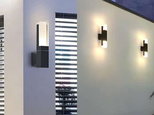 Double photo pour présenter une applique murale extérieure LED à tête simple ou à tête double. La première photo montre une applique simple sur une façade, et l'autre photo montre deux appliques double, éclairant en bas et en haut accrochées sur un mur de façade.