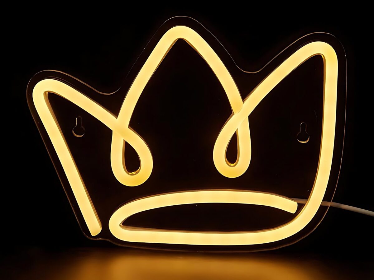 IMG_0924_ENSEIGNE_ COURONNE_NEON_LED_001 Couronne néon LED en silicone fixée au mur, émettant une lumière chaude, alimentée par un câble USB. La forme de couronne brille doucement.