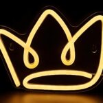 Enseigne couronne néon LED et silicone à accrocher Couronne néon LED en silicone fixée au mur, émettant une lumière chaude, alimentée par un câble USB. La forme de couronne brille doucement.
