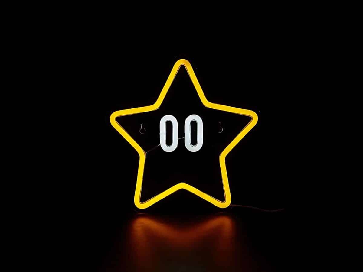 IMG_0924_ENSEIGNE_ ETOILE_NEON_LED_001 Enseigne Néon LED Étoile - Une étoile jaune lumineuse avec un contour en LED et un intérieur blanc, suspendue contre un mur, émettant une douce lueur pour créer une atmosphère chaleureuse.
