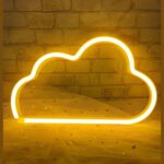Enseigne nuage néon LED et silicone à accrocher Enseigne nuage néon LED en silicone de couleur jaune, accrochée sur un mur texturé, illuminant la pièce d’une lumière douce et chaleureuse, câblage USB visible.