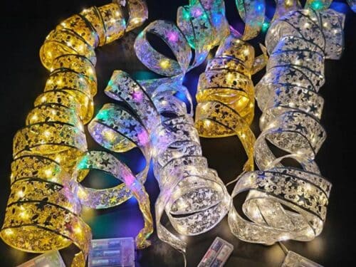 Cinq rubans lumineux LEd pour décorer le sapin de Noël ouverts en serpentins sur un fond noir.
