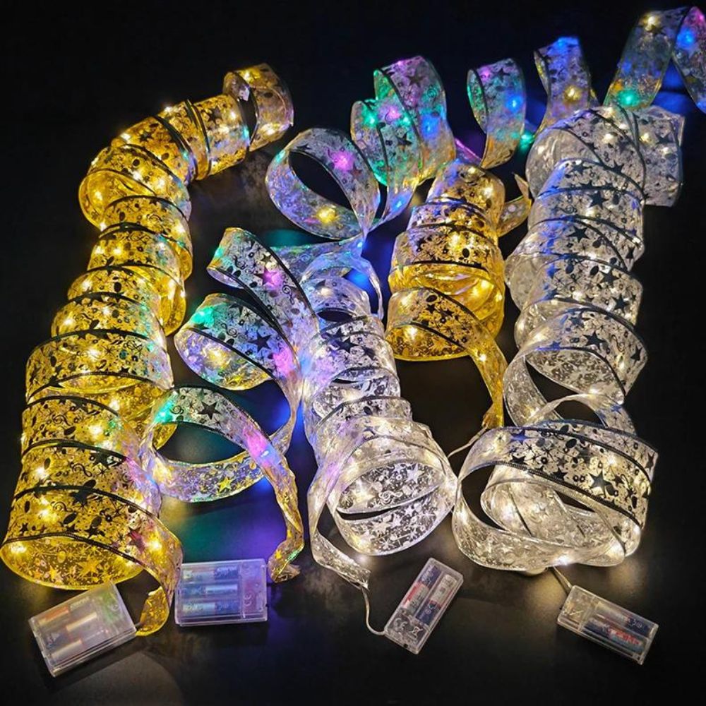 Ruban lumineux LED pour décoration de Noël Cinq rubans lumineux LEd pour décorer le sapin de Noël ouverts en serpentins sur un fond noir.